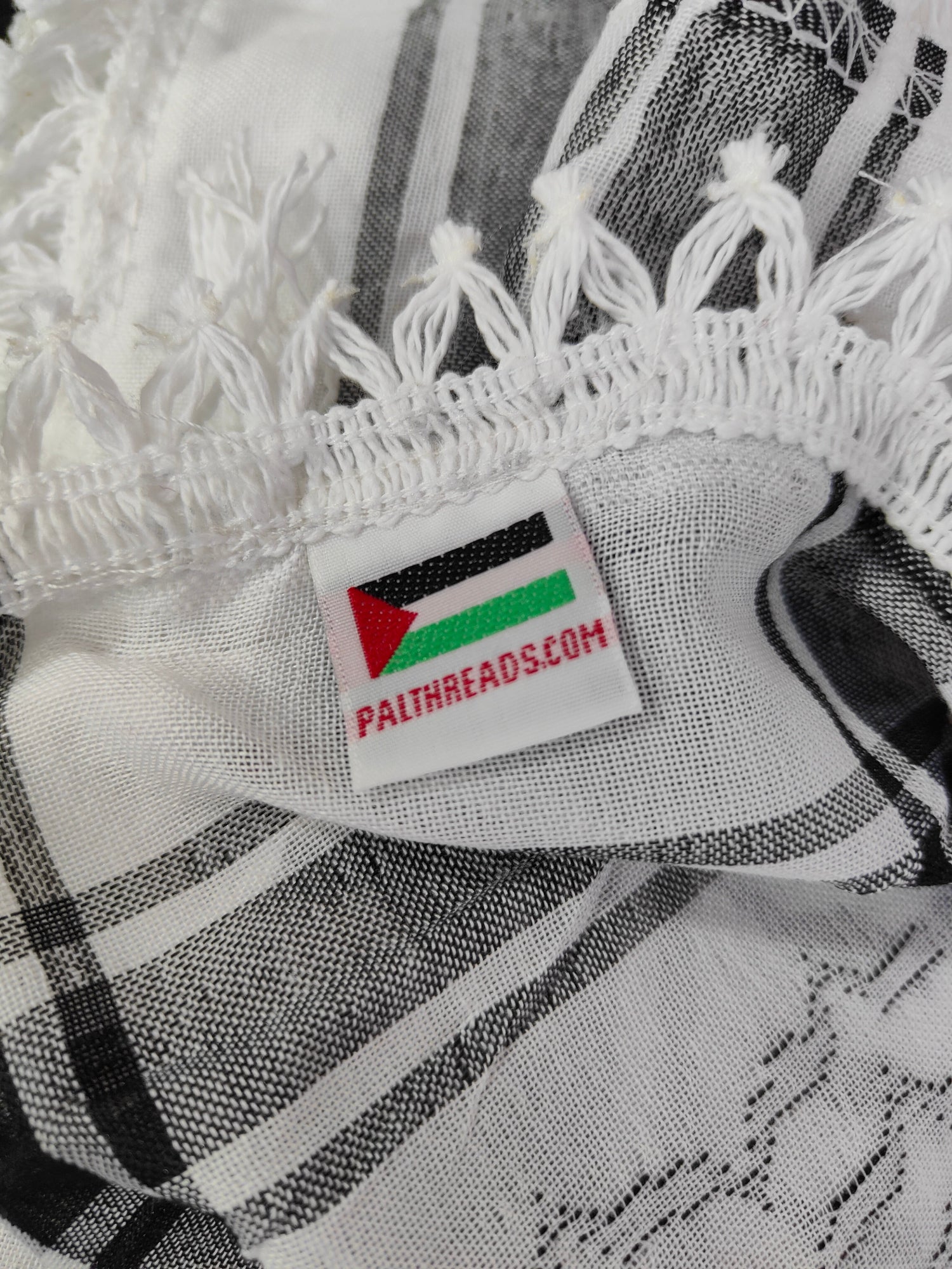 The traditional black and white keffiyeh is proudly made in Palestine and carries the original Palthreads.com label 